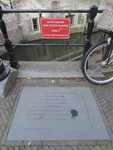 901994 Afbeelding van een natuursteen met een gedicht van Els van Stalborch in het plaveisel en een waarschuwingsbordje ...